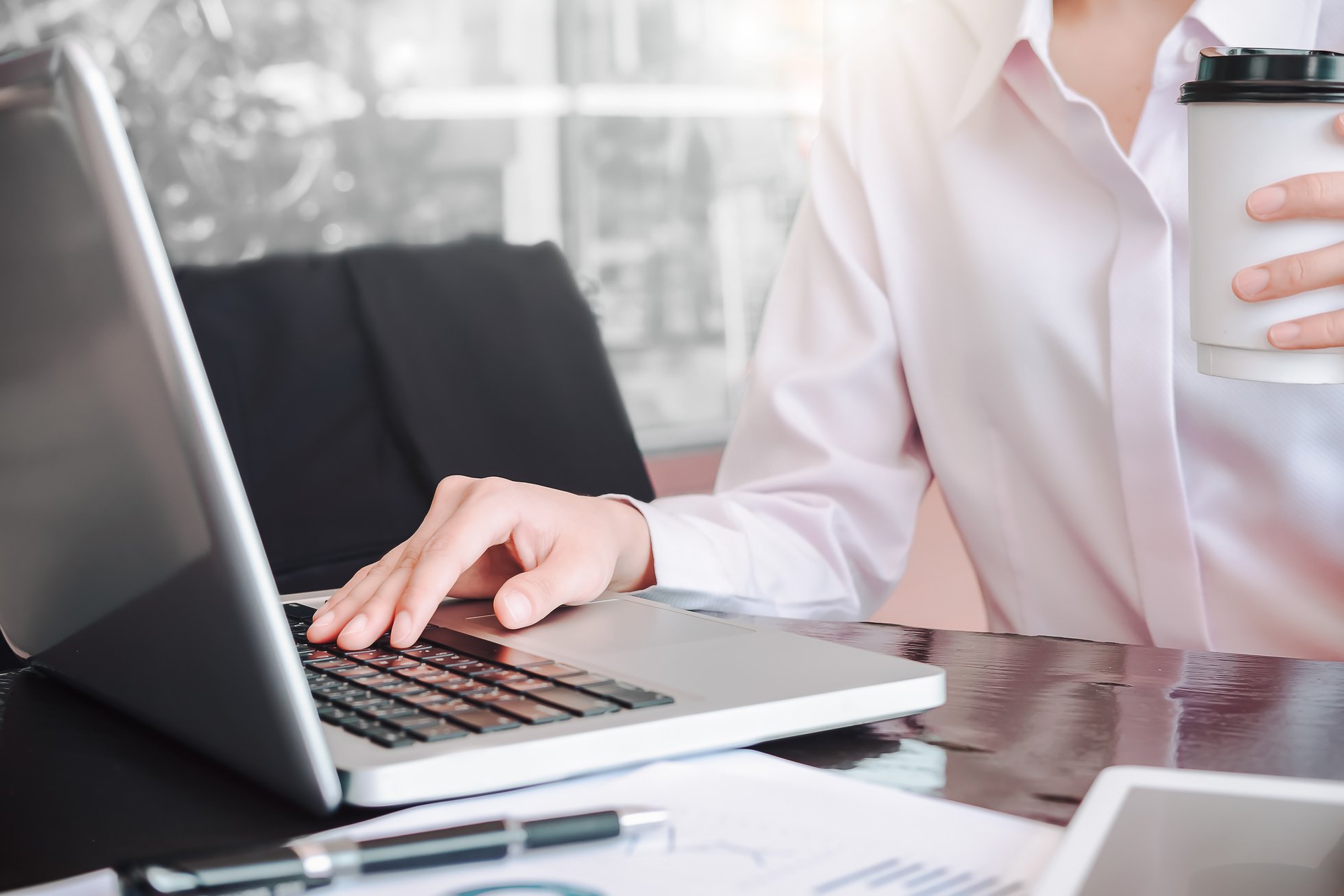 Girl with Cup of Coffee Working on Laptop